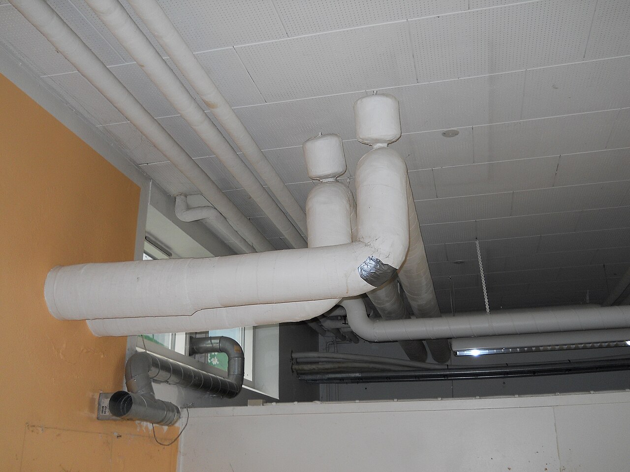 Old thermal insulation lagging wrapped around a heating pipe, the type of pipe lagging that may contain asbestos