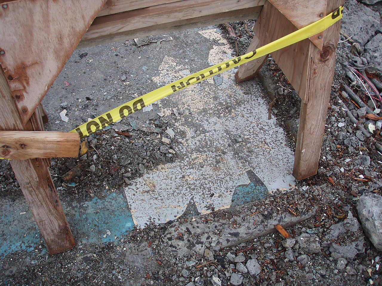 Old square thermoplastic floor tiles on a concrete floor, the type of vinyl floor tile that may contain asbestos